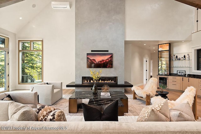 living room featuring a large fireplace, high vaulted ceiling, light hardwood / wood-style flooring, and plenty of natural light