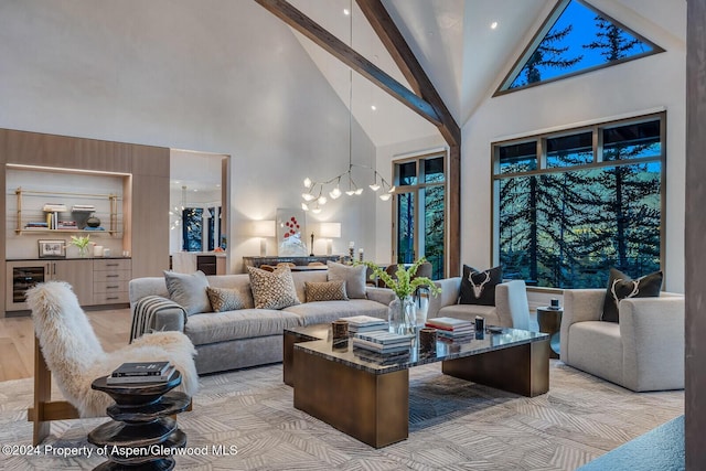 living room featuring wine cooler, beam ceiling, high vaulted ceiling, and a chandelier