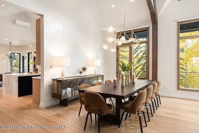 dining space featuring a chandelier, light hardwood / wood-style floors, a wall unit AC, and plenty of natural light