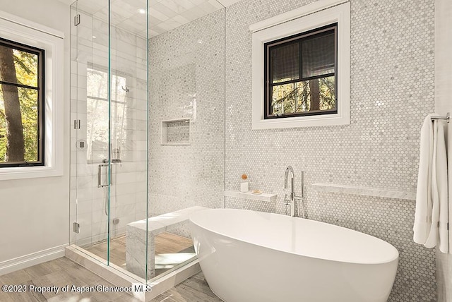 bathroom featuring plenty of natural light and tile walls