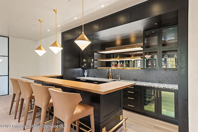 bar featuring tasteful backsplash and decorative light fixtures