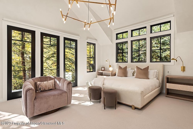 bedroom with a chandelier, carpet, and high vaulted ceiling