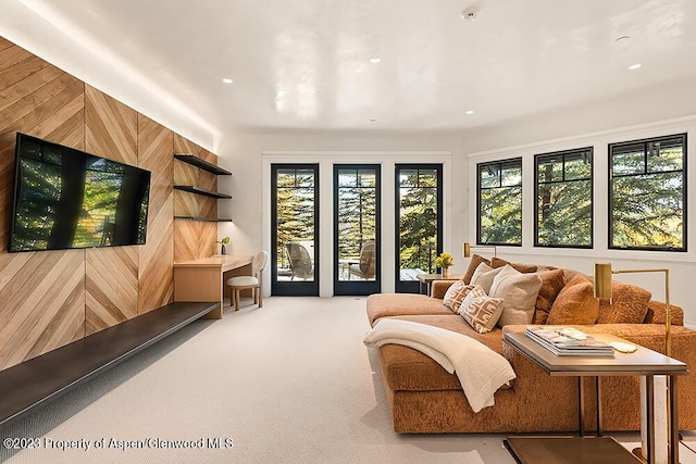 carpeted living room with wooden walls