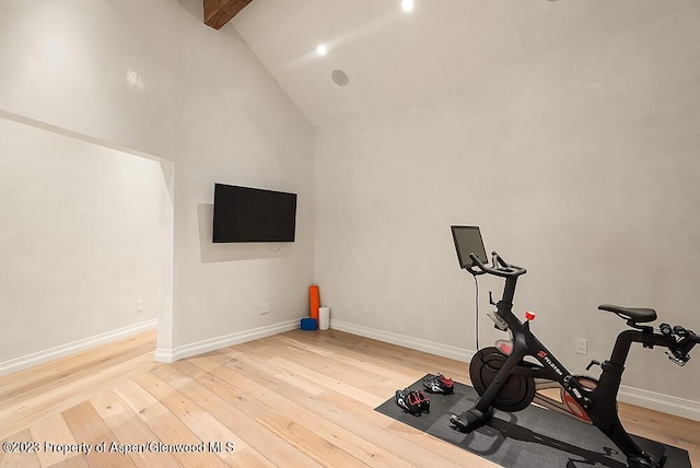 workout room featuring hardwood / wood-style floors and high vaulted ceiling