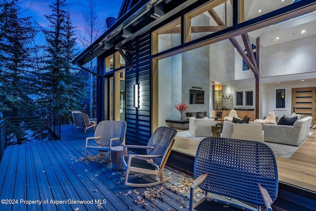 deck at dusk featuring an outdoor hangout area