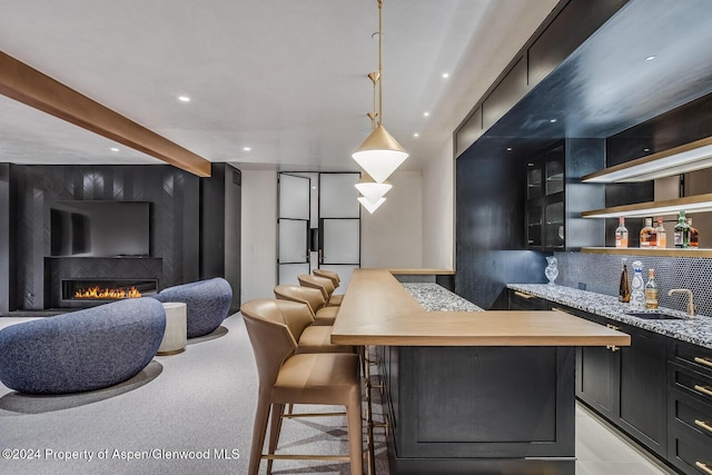 interior space featuring pendant lighting, beam ceiling, sink, and backsplash