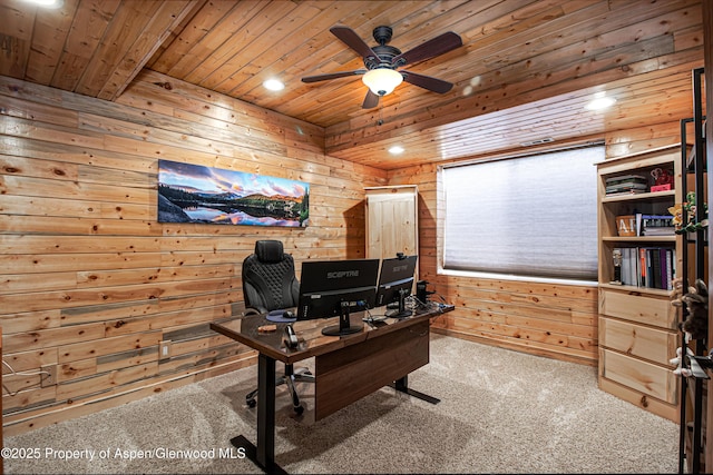 carpeted office space featuring wood ceiling, ceiling fan, and wood walls