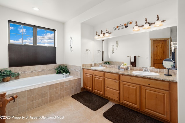 bathroom with vanity, a relaxing tiled tub, and tile patterned floors