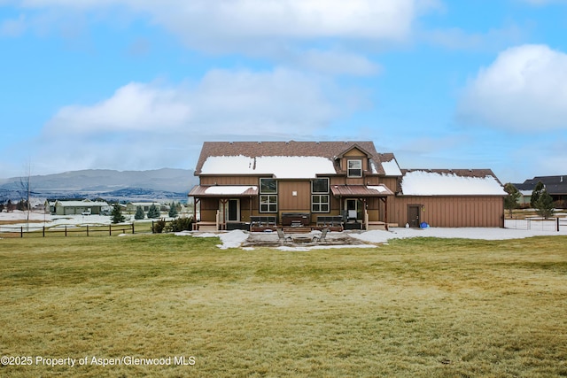 rear view of house with a mountain view and a yard