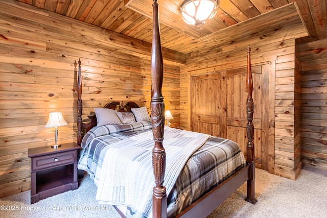 carpeted bedroom with wood ceiling and wooden walls