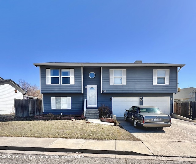 bi-level home with driveway, a garage, fence, and entry steps