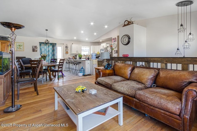 living room featuring lofted ceiling, light wood finished floors, and recessed lighting