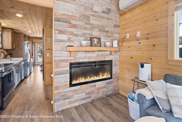 329 River Frontage Rd # 65, Silt, CO 81652 - living area featuring wood finished floors, a stone fireplace, recessed lighting, wood walls, and an AC wall unit