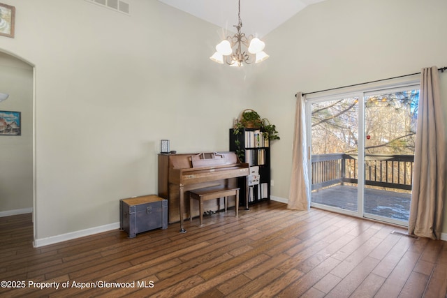 misc room featuring an inviting chandelier, dark hardwood / wood-style flooring, and high vaulted ceiling