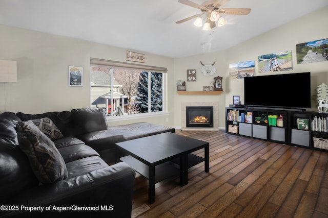 living room with ceiling fan, dark wood-type flooring, and a fireplace