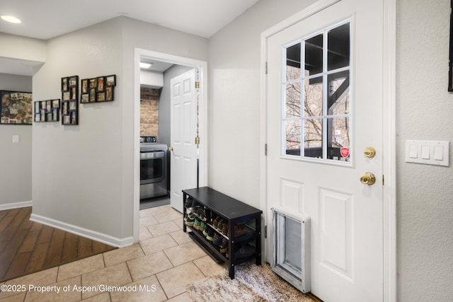 foyer with washer / clothes dryer and light tile patterned floors