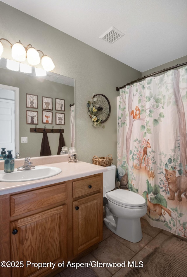 bathroom with tile patterned flooring, vanity, walk in shower, and toilet