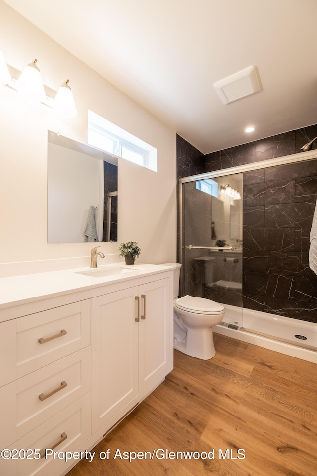 1720 Belgian Loop, Silt, CO 81652 - full bathroom featuring vanity, toilet, a stall shower, and wood finished floors