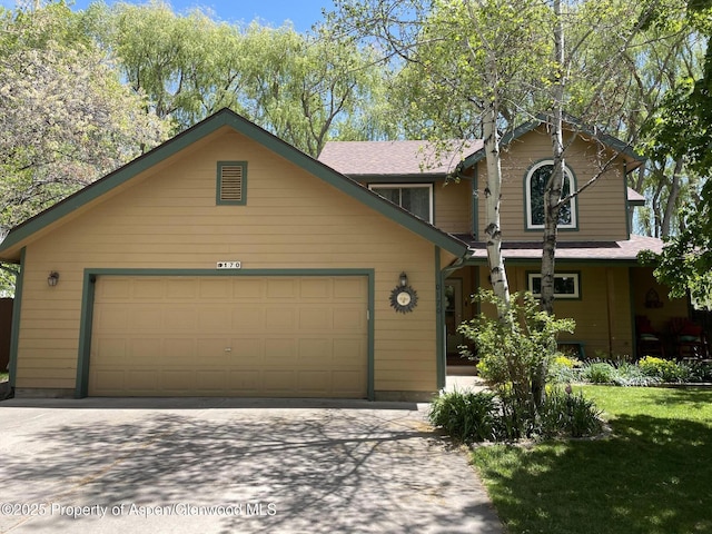 170 Deer Run, Carbondale, CO 81623 - view of front of house featuring concrete driveway, an attached garage, and a front lawn