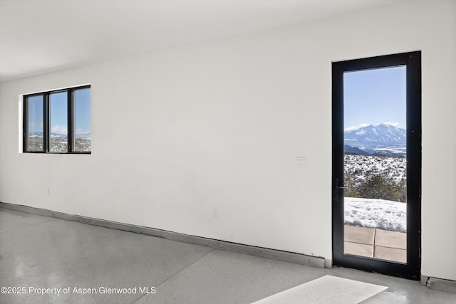 unfurnished room featuring plenty of natural light and a mountain view