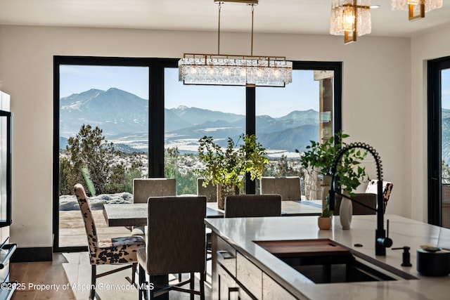 dining space featuring a mountain view, sink, and light hardwood / wood-style flooring