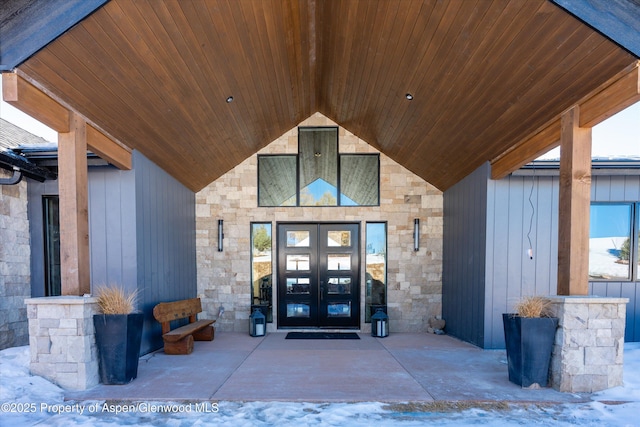 snow covered property entrance featuring french doors