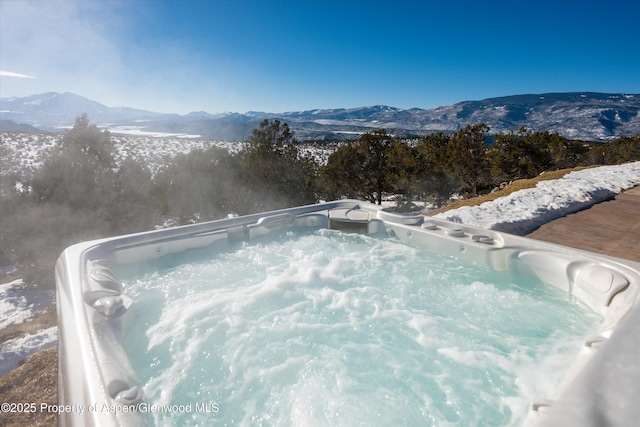 view of swimming pool with a hot tub and a mountain view