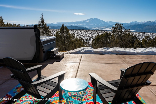 snow covered patio featuring a mountain view