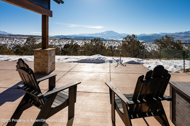 snow covered patio with a mountain view