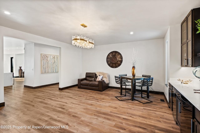 dining room with a notable chandelier and light wood-type flooring