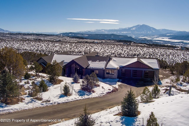 snowy aerial view with a mountain view