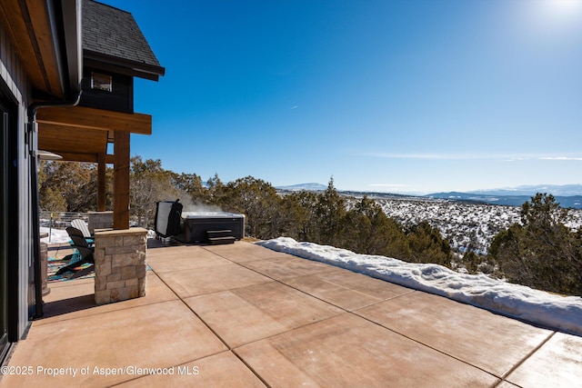 snow covered patio with a mountain view