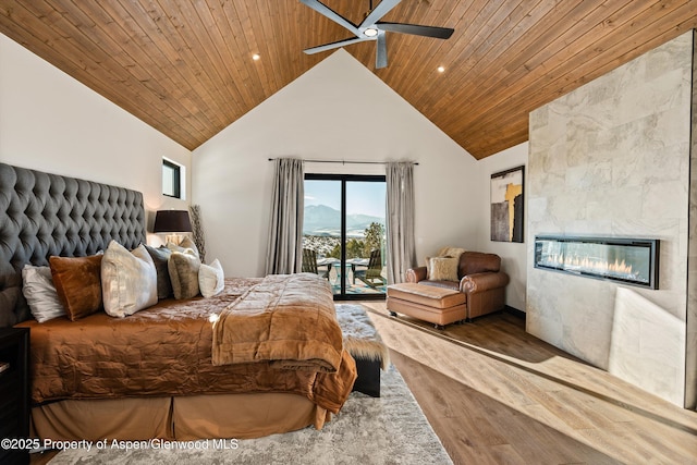 bedroom with a tile fireplace, access to exterior, hardwood / wood-style floors, high vaulted ceiling, and wooden ceiling