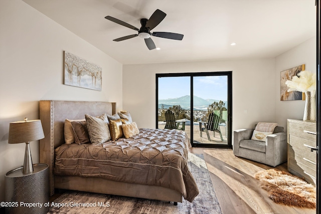 bedroom featuring wood-type flooring, a mountain view, access to exterior, and ceiling fan