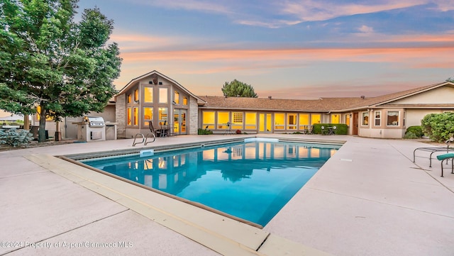 pool at dusk with a patio