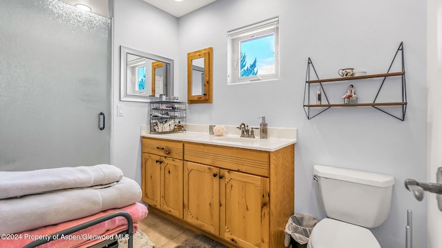 bathroom with toilet, vanity, tile patterned floors, and a shower with shower door