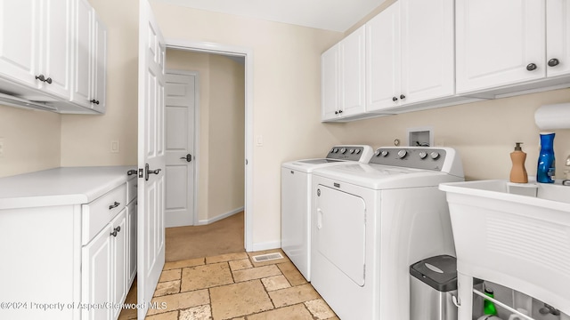 laundry room with cabinets, independent washer and dryer, and sink