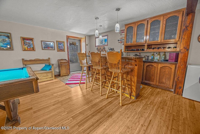 550 County Road 22, Craig, CO 81625 - recreation room featuring wet bar, light wood-style flooring, a textured ceiling, and pool table