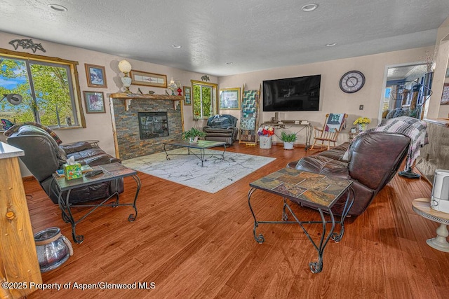 550 County Road 22, Craig, CO 81625 - living room with a textured ceiling, plenty of natural light, a fireplace, wood finished floors, and recessed lighting