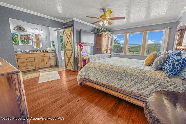 550 County Road 22, Craig, CO 81625 - bedroom featuring ornamental molding, a textured ceiling, a textured wall, light wood-style floors, and a ceiling fan
