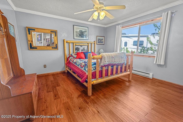 550 County Road 22, Craig, CO 81625 - bedroom featuring wood finished floors, a baseboard radiator, ornamental molding, a textured ceiling, and a ceiling fan