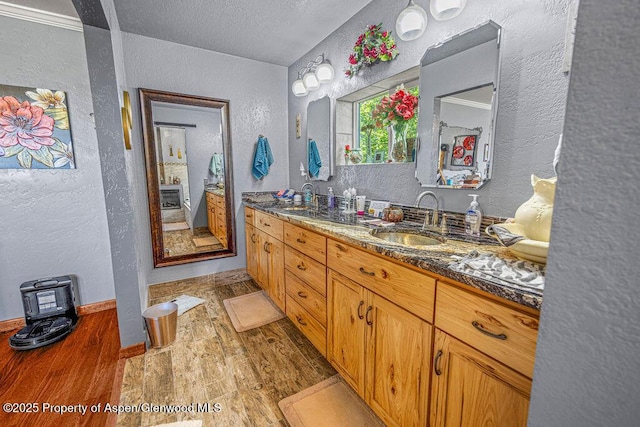550 County Road 22, Craig, CO 81625 - bathroom with a textured wall, wood finished floors, double vanity, and a textured ceiling