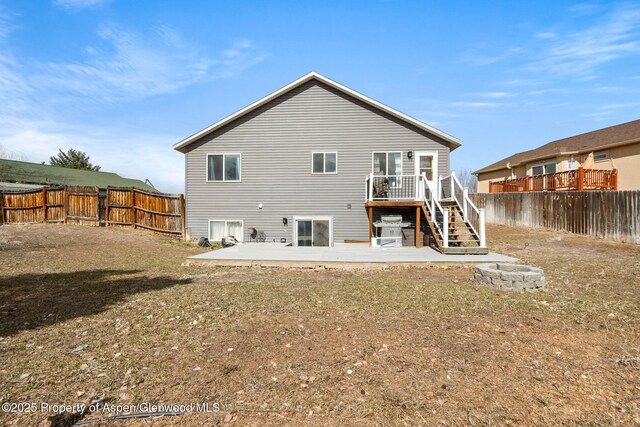 rear view of property featuring a fenced backyard, stairs, and a patio area