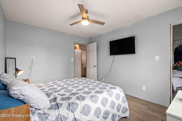 bedroom with a closet, wood finished floors, and a ceiling fan