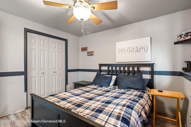 bedroom with a closet, wood finished floors, and a ceiling fan