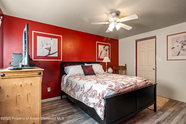bedroom with ceiling fan, baseboards, and wood finished floors