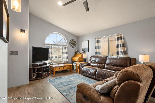 living room featuring lofted ceiling, wood finished floors, and a ceiling fan