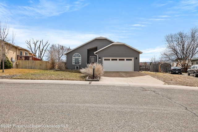 view of front of home with concrete driveway, fence, a garage, and a front yard