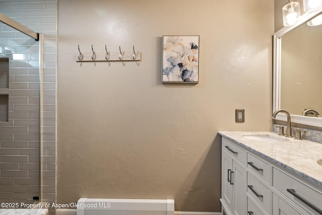 full bathroom with double vanity, walk in shower, and a sink