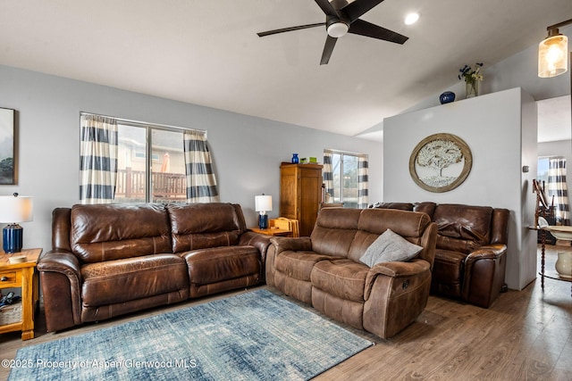 living area featuring a wealth of natural light, lofted ceiling, wood finished floors, and a ceiling fan